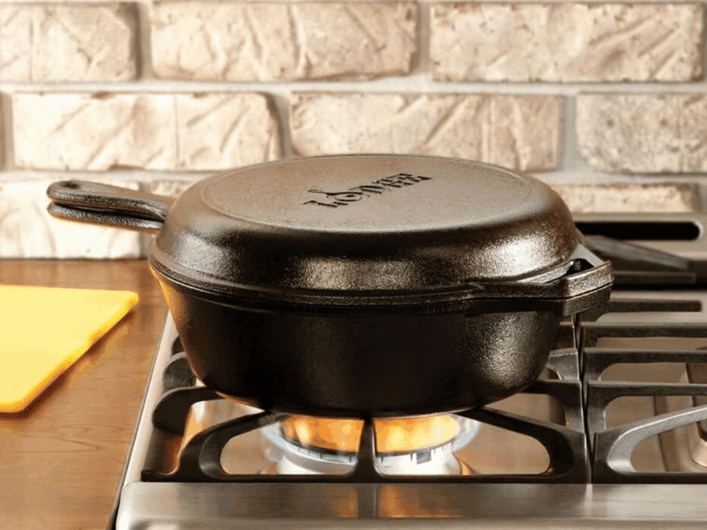 Cast Iron pot and pan combo on a range stove with stone tile background