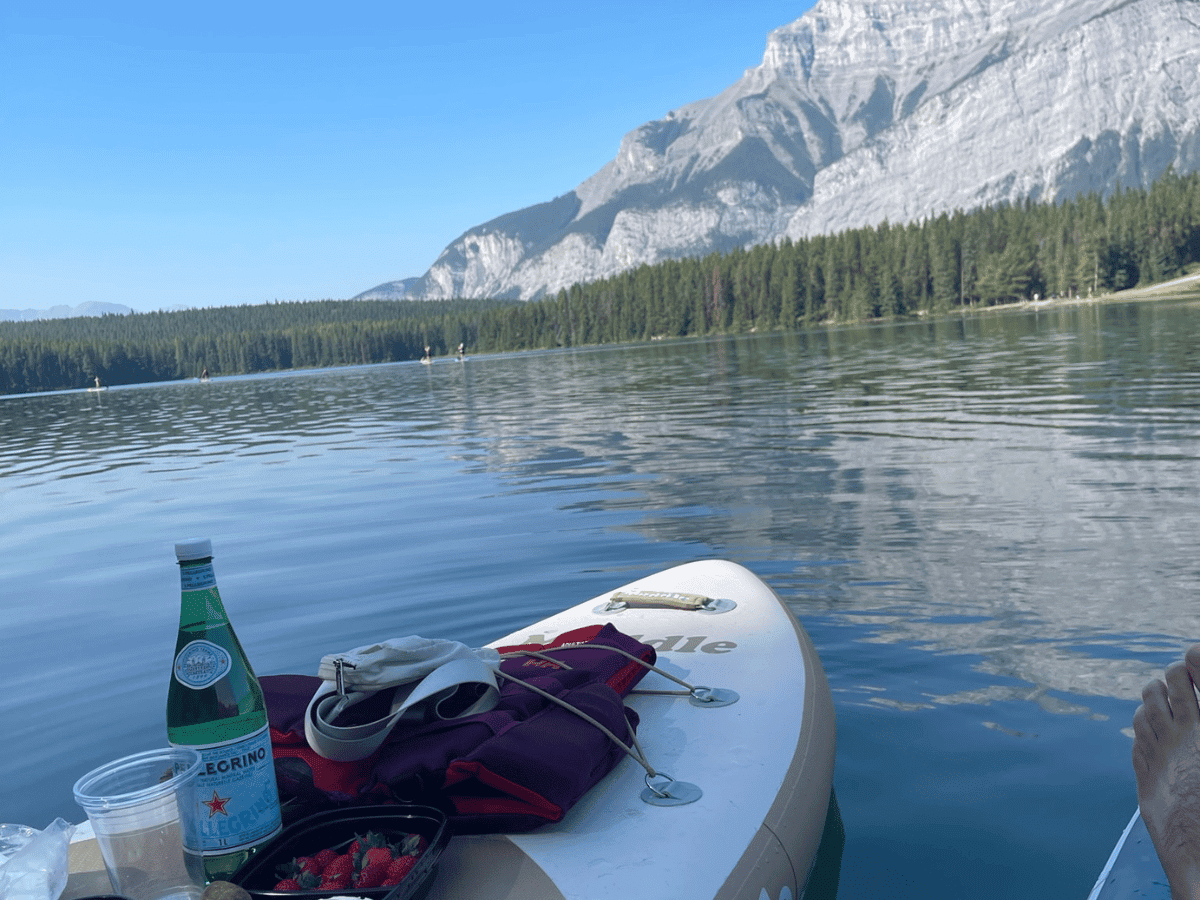 having a picnic on paddle boards in two jack lake with mountain views 