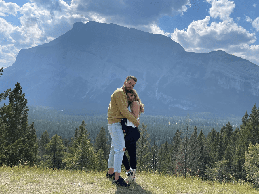 Couple overlooking the Bow Valley from Tunnel Mountain campground in Banff National Park with forest and mountain views.